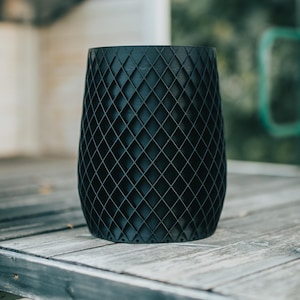 May include: A black planter with a diamond-shaped pattern. The planter is made of a durable material and has a modern design.