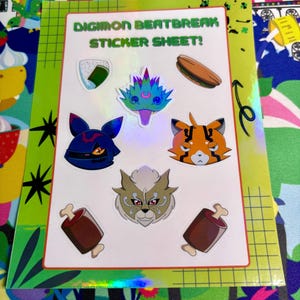 May include: A rectangular sticker sheet titled DIGIMON BEATBREAK STICKER SHEET! featuring various die-cut stickers including a blue creature, a cat-like character, a lion-like face, a rice ball, a sandwich, and two brown meat-on-the-bone icons.