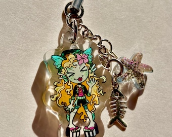 May include: A clear acrylic charm featuring a cartoon mermaid with blonde hair, a pink flower, and a black outfit. The charm includes a starfish and a fishbone charm, attached to a silver chain and black cord.