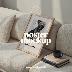May include: A wooden framed poster mockup with a black and white illustration of two people. The poster is on a light beige couch with two pillows. The text on the poster reads "SIMPLICITY".