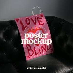 Può includere: Un mockup di poster rosa con il testo "Love is Blind" in un font stilizzato. Il poster presenta un cuore rosso con fiamme e un contorno bianco. Il poster è appoggiato su un divano in pelle nera.
