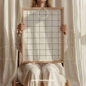 May include: A person holding a wooden frame with a white poster inside. The poster has a grid pattern on it. The text "HIGH QUALITY - REALISTIC MOCKUP" is printed on the frame.