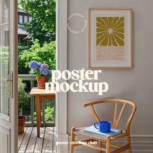 以下が含まれることがあります： 黄色の抽象的なデザインが施された額縁に入ったポスターのモックアップ。ポスターは、木製の椅子と小さなテーブルのある部屋の薄い灰色の壁に掛けられています。壁には白い文字で「ポスターモックアップ」と書かれています。