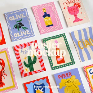 May include: A collection of colorful art prints with various designs. The prints feature illustrations of olives, a cactus, a cocktail, a cat, and a bottle of rum. Each print has a unique border and text, including "OLIVE," "Cheers," and "PURRR."