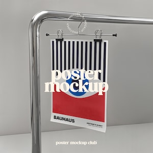Może przedstawiać: Makieta plakatu z czarno-białym paskowanym tłem, czerwono-niebieskim geometrycznym wzorem i tekstem "poster mockup" w kolorze białym. Plakat jest zawieszony na metalowym pręcie z dwoma czarnymi klipsami. Tekst "BAHAUS" i "ABSTRAKTE KUNST" jest widoczny u dołu plakatu.