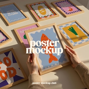 May include: Several framed art prints with diverse designs. One print shows an orange fish on a blue backdrop, others display text and illustrations. The frames are light wood, and the overall aesthetic is modern and colourful.