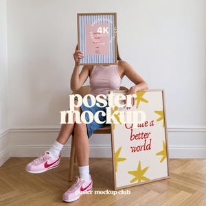 Könnte beinhalten: Eine Person hält zwei gerahmte Poster. Eines hat ein rosa-blaues Streifendesign mit Text, das andere gelbe Sterne und die Worte "Create a better world". Die Person trägt rosa Turnschuhe.