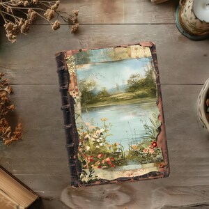 May include: A vintage, leather-bound journal with a colourful, collage-style cover featuring a painted landscape scene of a lake and trees. The cover is worn and distressed, giving it a rustic and antique look.