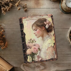 May include: A vintage-style book with a portrait of a woman in a white dress holding a bouquet of pink roses. The book has a distressed, brown leather cover and a decorative pink bow in the woman's hair. The background is a soft, pastel yellow.