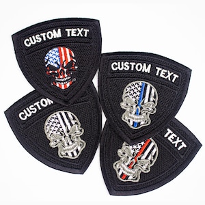 May include: Four black embroidered patches with a skull design. Each skull is a different color: red, white, and blue; blue and white; black and white; and red and white. The patches have the text "CUSTOM TEXT" on them.