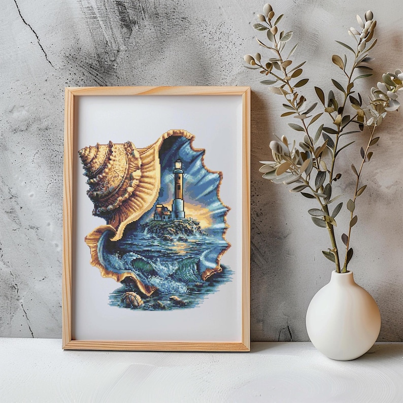 May include: A framed print featuring a lighthouse scene within a seashell. The artwork depicts a lighthouse on a rocky island, with waves crashing below and a sunset in the background. The frame is made of light-colored wood.