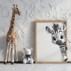 Könnte beinhalten: Eine Giraffenfigur mit braunen und weißen Markierungen steht neben einem weißen Teddybären mit schwarzer Schleife. Ein gerahmtes Bild zeigt ein Zebra, das hervorlugt. Der Hintergrund ist eine strukturierte weiße Wand.