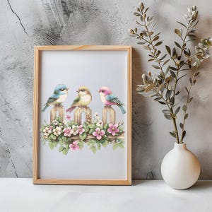 以下が含まれることがあります： ピンクと白の花が咲く木製のフェンスにとまっている、カラフルな鳥3羽の額装されたプリント。鳥は青、緑、ピンクです。
