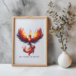 Peut inclure: Un cadre en bois clair encadre une œuvre d'art représentant un phénix flamboyant aux couleurs rouge, orange et jaune. Le texte "BE STRONG BE BETTER" est inscrit en bas. Une décoration murale inspirante.