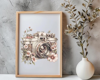 May include: A framed print of a vintage camera with delicate pink and white flowers surrounding it. The camera is silver and gold with a black lens. The background is a light blue.