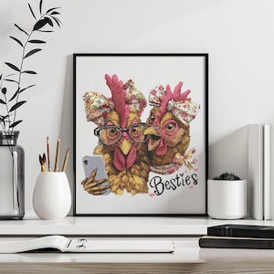 Può includere: Opera d'arte incorniciata con due galline con fasce floreali. Una gallina indossa occhiali e tiene un telefono, l'altra sorride. La parola "Besties" è scritta sotto in corsivo.