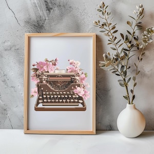 Könnte beinhalten: Gerahmter Druck mit einer braunen Vintage-Schreibmaschine, verziert mit rosa Blüten. Die Schreibmaschine hat silberne Tasten und steht vor einem hellblauen Hintergrund. Der Holzrahmen ergänzt das florale und literarische Thema.