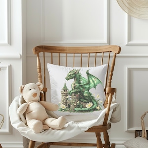 May include: A white pillow with a green dragon sitting on a stone tower. The dragon has a green body, brown wings, and a red crest. The tower is covered in green vines and flowers.