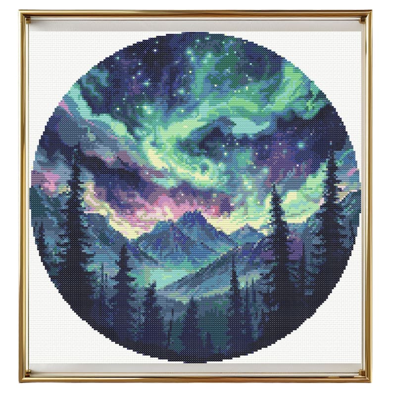 Puede incluir: Un patr&oacute;n de punto de cruz circular que representa una cordillera silueteada contra una vibrante aurora boreal. El cielo est&aacute; lleno de matices de verde, morado y rosa, con una dispersi&oacute;n de estrellas. Las monta&ntilde;as son de un azul profundo, y los &aacute;rboles en primer plano son negros.