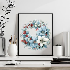 May include: A framed watercolor print of a floral wreath. The wreath features blue and white flowers, red berries, and green leaves. The artwork is displayed on a white surface with other decorative items.