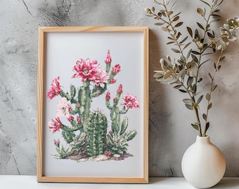 May include: A framed cross-stitch art piece featuring a detailed depiction of a flowering cactus. The artwork showcases a variety of cacti with green bodies and vibrant pink blooms. The frame is made of light-colored wood, adding a natural touch to the piece.