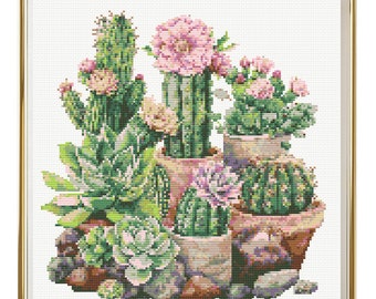 May include: A framed cross-stitch embroidery featuring a collection of cacti and succulents in various shades of green, pink, and brown. The cacti are potted in terracotta pots with a white background.
