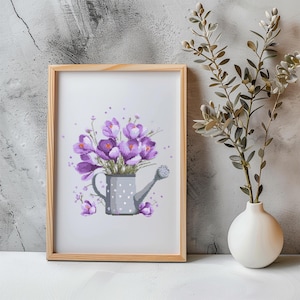 Puede incluir: Una obra de arte en punto de cruz enmarcada con un ramo de flores de crocus moradas en una regadera gris con lunares blancos. La obra de arte está en un marco de madera marrón claro, sobre un fondo gris texturizado.
