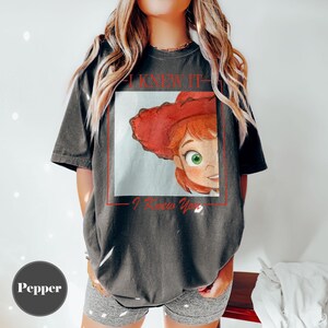 K&ouml;nnte beinhalten: Ein anthrazitfarbenes Kurzarm-T-Shirt mit einem quadratischen Grafikdruck einer Zeichentrickfigur mit roten Haaren und einem roten Hut. Der Text I KNEW IT ist &uuml;ber der Grafik und I Knew You ist darunter in roter Schrift aufgedruckt.