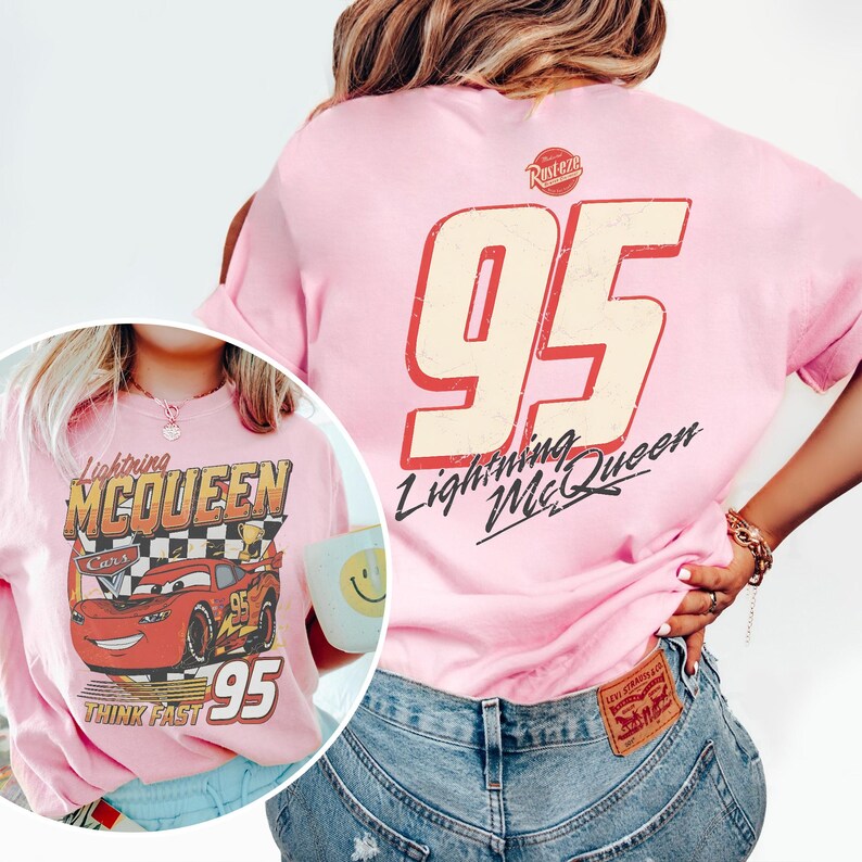 May include: Pink t-shirt featuring Lightning McQueen from the Cars movie. The front graphic shows McQueen with the text "Lightning McQueen Cars" and "95". The back of the shirt displays a large "95" and "Lightning McQueen" text.