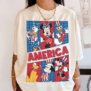 May include: A set of three ceramic mugs with a speckled, cream-colored glaze. Each mug features a different hand-painted design: a blue and green leaf, a yellow flower, and a red berry. The mugs have a simple, modern design.