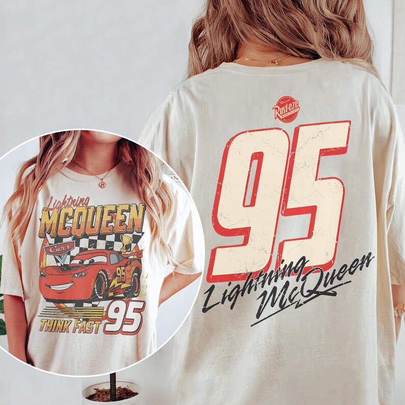 May include: Cream-colored t-shirt featuring a graphic of Lightning McQueen from the Cars movie. The front design includes the character, the number 95, and the words "Lightning McQueen" and "Think Fast." The back displays a large number 95.