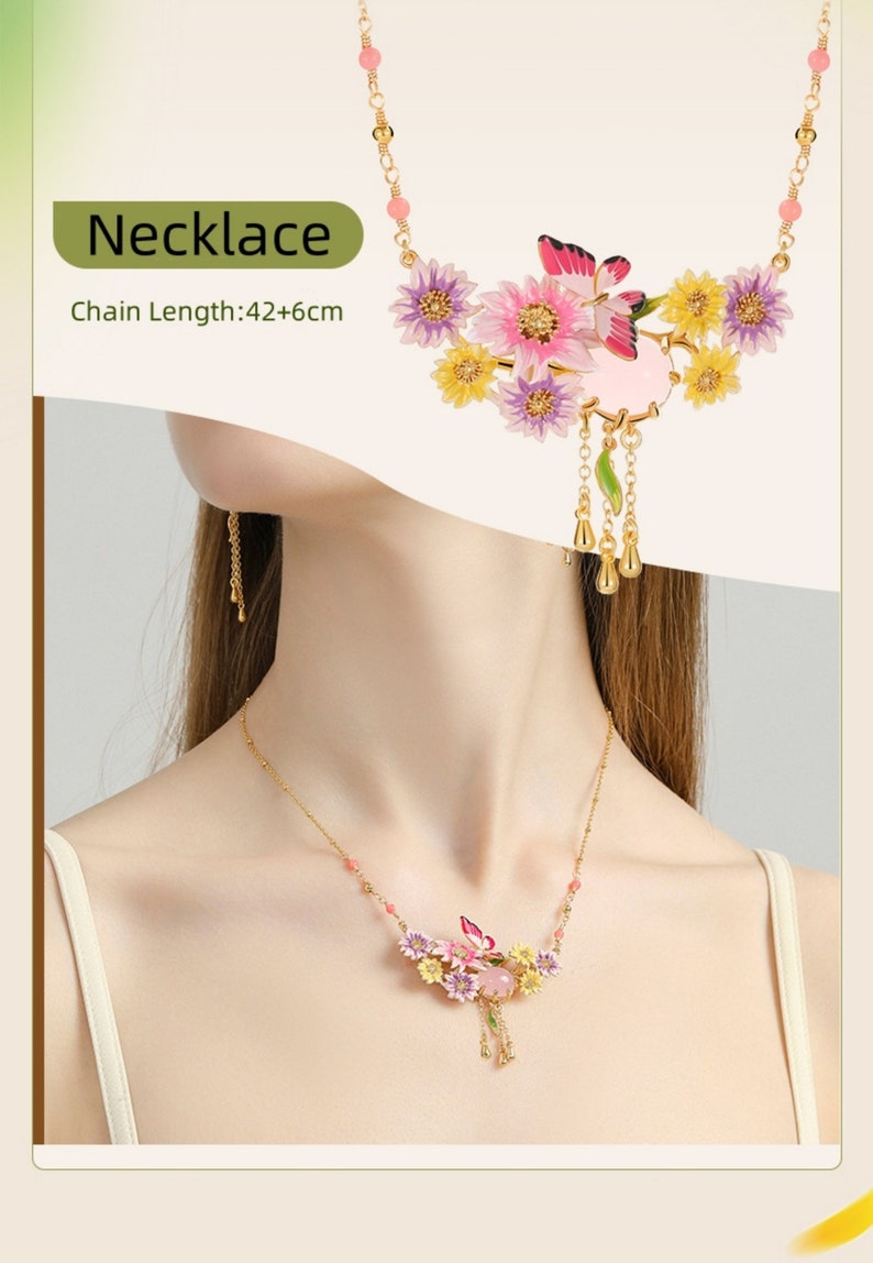 May include: A gold necklace with a pink, yellow, and purple flower pendant. The pendant features a butterfly and a pink stone. The chain is 42 inches long with a 6-inch extender.