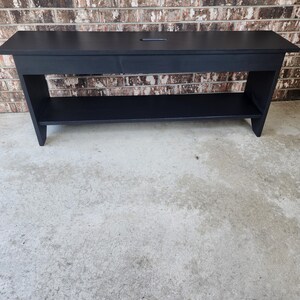 May include: A black wooden bench with a shelf underneath. The bench has a simple design and is made of solid wood.