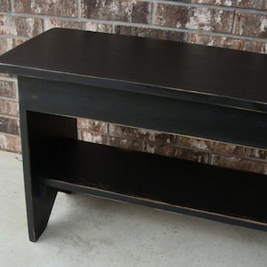 May include: Black wooden bench with a shelf underneath. The bench has a distressed finish and is made of solid wood.