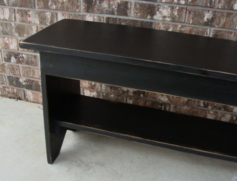 May include: Black wooden bench with a shelf underneath. The bench has a distressed finish and is made of solid wood.
