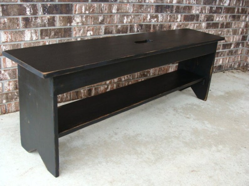 May include: Black wooden bench with a shelf and a cutout in the top. The bench has a distressed finish.