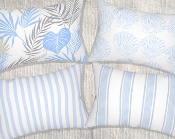 May include: Four decorative throw pillows with various patterns. One pillow features blue and gray tropical leaves on a white background. Another has blue seashell patterns. The other two pillows have blue and white vertical stripes.