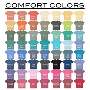 Pu&ograve; includere: Una tabella di 48 colori diversi visualizzati su magliette. I colori sono disposti in righe e colonne, con ogni colore etichettato con un nome. La tabella &egrave; intitolata "Comfort Colors".
