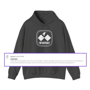 Puede incluir: Una sudadera con capucha gris oscuro con un gr&aacute;fico blanco de un esquiador en un diamante doble con el texto "I'M DIFFICULT". La sudadera tiene una calificaci&oacute;n de cinco estrellas y una rese&ntilde;a que dice "Me encanta esta sudadera. Suave, c&aacute;lida y c&oacute;moda. Ped&iacute; una talla m&aacute;s grande porque estaba preocupado, seg&uacute;n las medidas, de que mi talla normal fuera un poco ajustada. Creo que mi talla normal habr&iacute;a estado bien, pero me gusta c&oacute;mo queda la talla m&aacute;s grande."