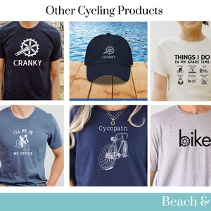 May include: A collection of cycling-themed apparel and accessories. The items include a navy blue t-shirt with a bicycle graphic and the text "I'll be in my office", a gray t-shirt with the word "bike" in black, a navy blue t-shirt with a bicycle graphic and the text "Cycopath", a white t-shirt with the text "Things I do in my spare time" and a list of cycling activities, a navy blue t-shirt with a bicycle graphic and the text "Cranky", and a navy blue baseball cap with the text "Cranky".