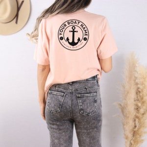 May include: A pink t-shirt with a black anchor design on the back. The design includes the text "Your Boat Name" and "Vintage Maritime".