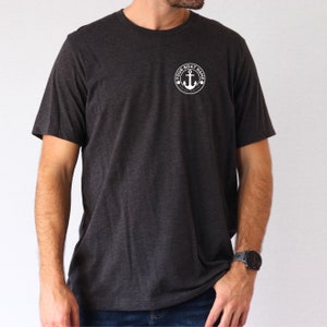 May include: A dark heather grey t-shirt with a white anchor and the text "YOUR BOAT NAME" in a circle on the left chest.