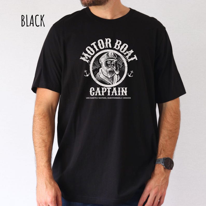 May include: Black t-shirt with a white graphic of a captain with a beard and a pipe. The graphic is in a circle with the words "Motor Boat Captain" and "Uncharted Waters, Questionable Choices" written below.