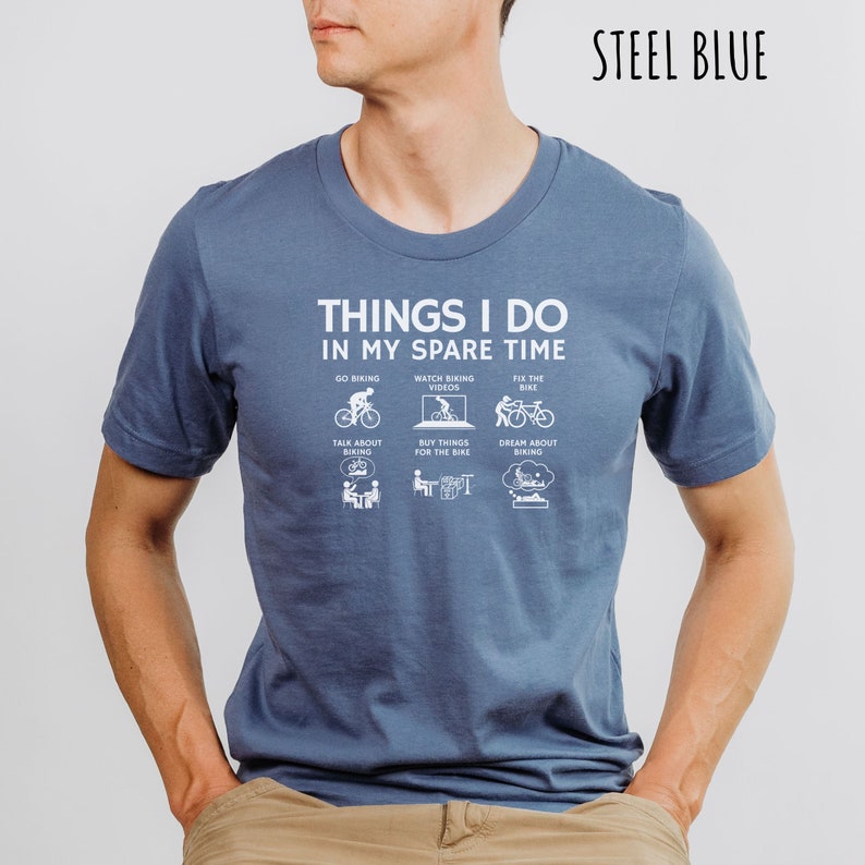 May include: A steel blue t-shirt with a white graphic that says "Things I do in my spare time" and lists activities related to cycling.