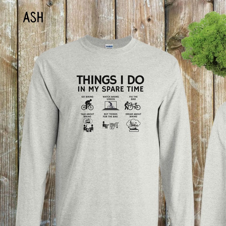 May include: A gray long-sleeve t-shirt with the text "THINGS I DO IN MY SPARE TIME" and a series of black and white illustrations depicting activities related to biking.
