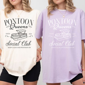 Pu&ograve; includere: Due t-shirt oversize con un design grafico di una barca ponton e il testo "Pontoon Queens Social Club Est. 2024 Keep Calm and Pontoon On". La maglietta a sinistra &egrave; avorio e la maglietta a destra &egrave; orchidea.