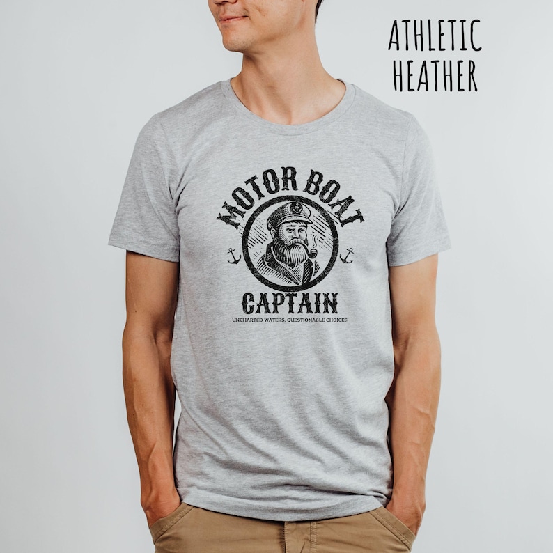 May include: A gray t-shirt with a black graphic of a captain with a pipe and the text "Motor Boat Captain Uncharted Waters, Questionable Choices".