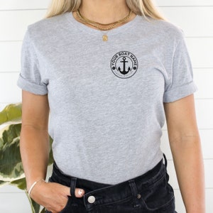 May include: A gray t-shirt with a black anchor and the text "YOUR BOAT NAME VINTAGE MARITIME" in a circle.