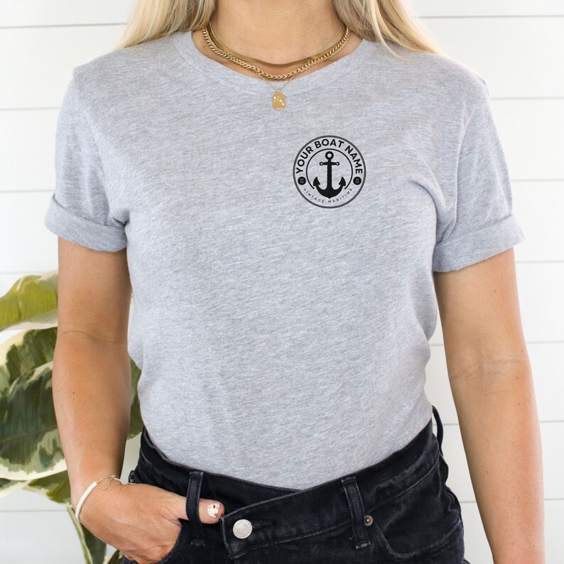 May include: A gray t-shirt with a black anchor and the text "YOUR BOAT NAME VINTAGE MARITIME" in a circle.