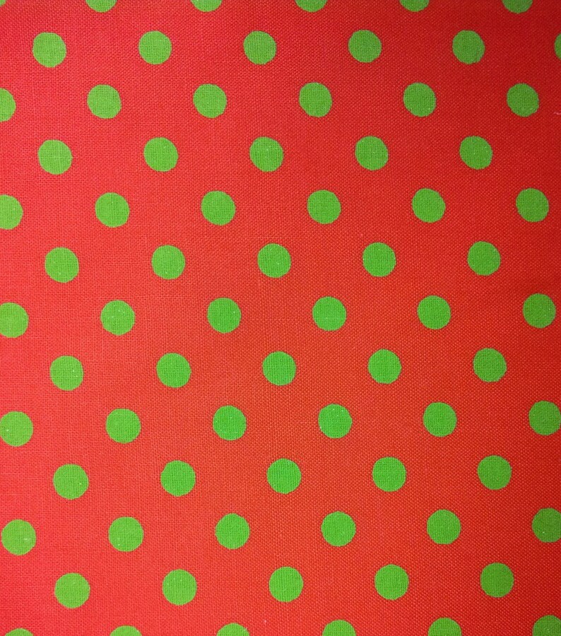 May include: Red fabric with a repeating pattern of green polka dots.